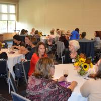 Overview photo of alumni sitting at the tables at the KCON alumni reception